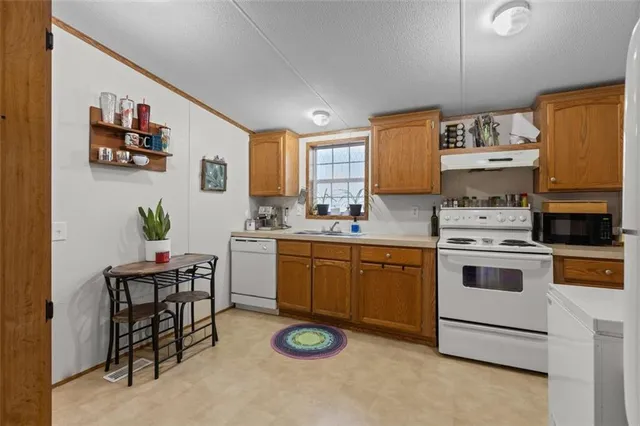 a kitchen with stainless steel appliances a stove a sink cabinets and a window