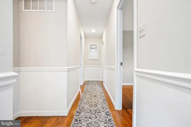 a view of a hallway with wooden floor and staircase