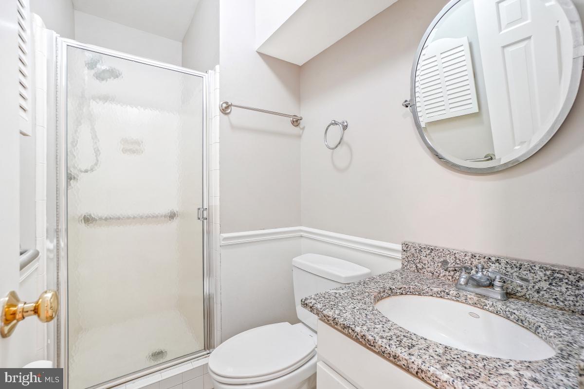 6871 Churchill Road McLean, VA 22101 - Photo 25 of 30 a bathroom with a granite countertop sink mirror and toilet