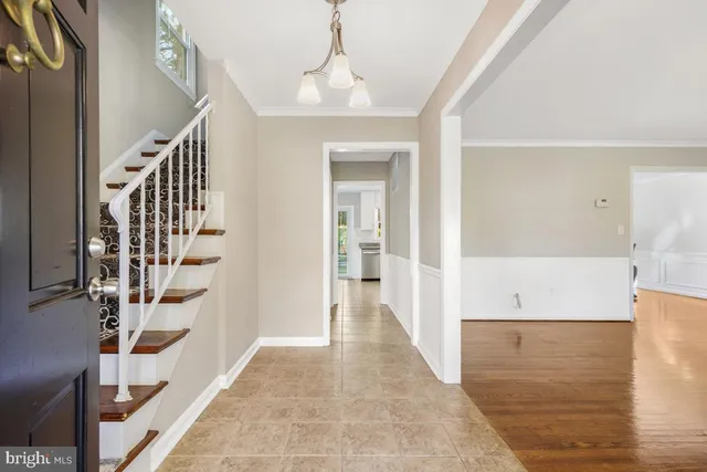 a view of a hallway with wooden floor and staircase