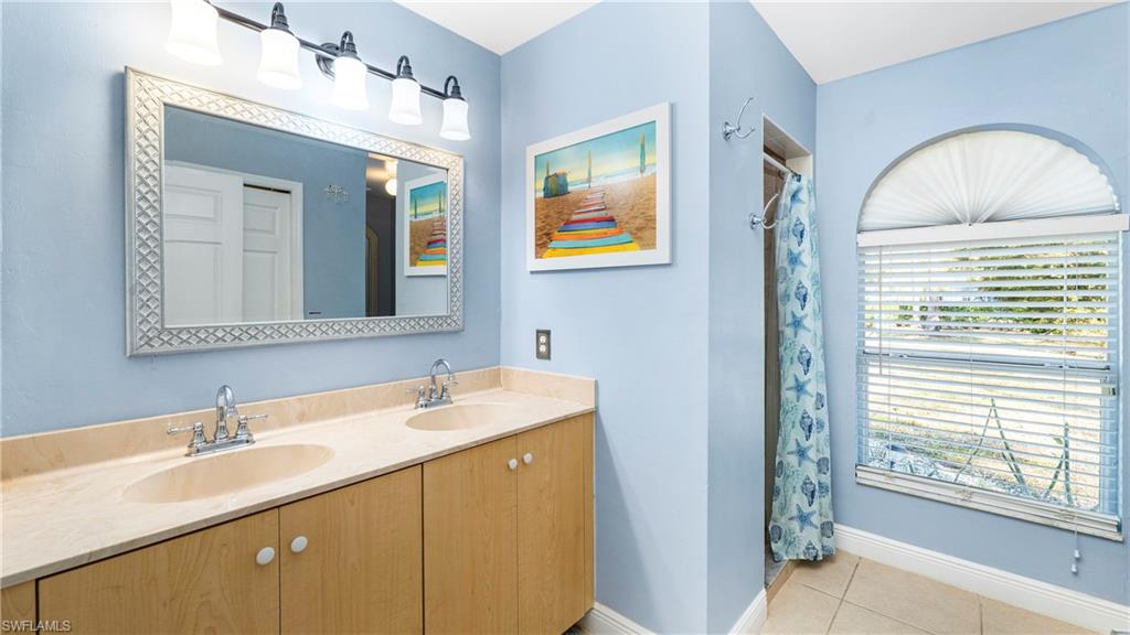 3340 2nd Avenue Southeast Naples, FL 34117 - Photo 12 of 25 a bathroom with a double vanity sink and a mirror
