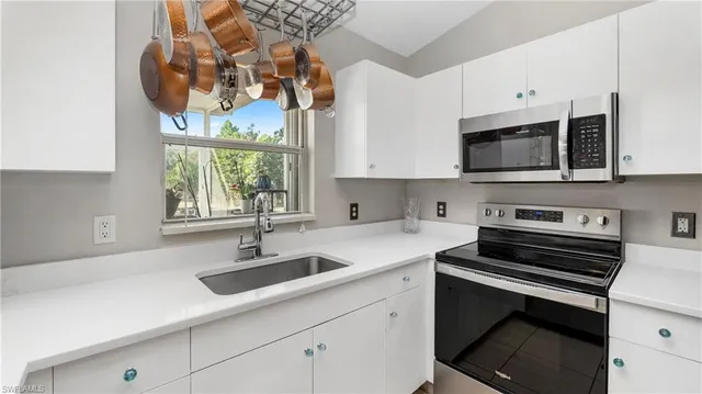 a kitchen with stainless steel appliances a sink a stove and microwave