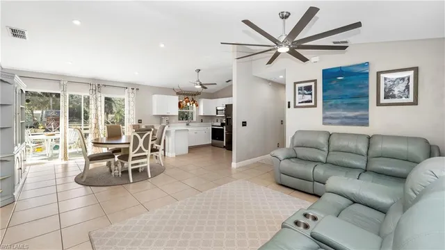 a living room with furniture a clock and a ceiling fan