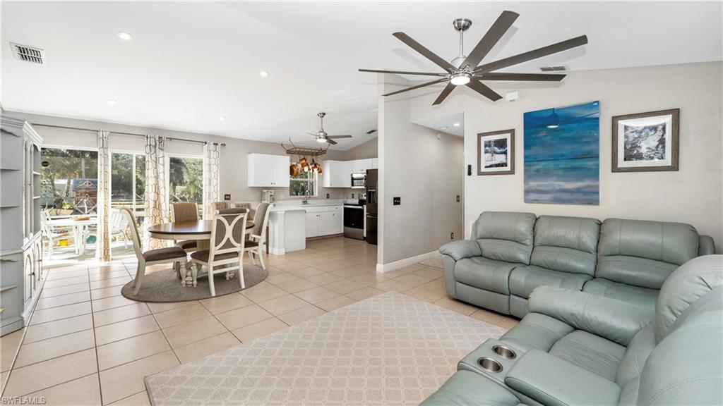 3340 2nd Avenue Southeast Naples, FL 34117 - Photo 7 of 25 a living room with furniture a clock and a ceiling fan
