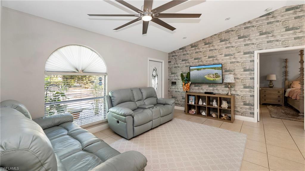 3340 2nd Avenue Southeast Naples, FL 34117 - Photo 9 of 25 a living room with furniture a fireplace and a flat screen tv