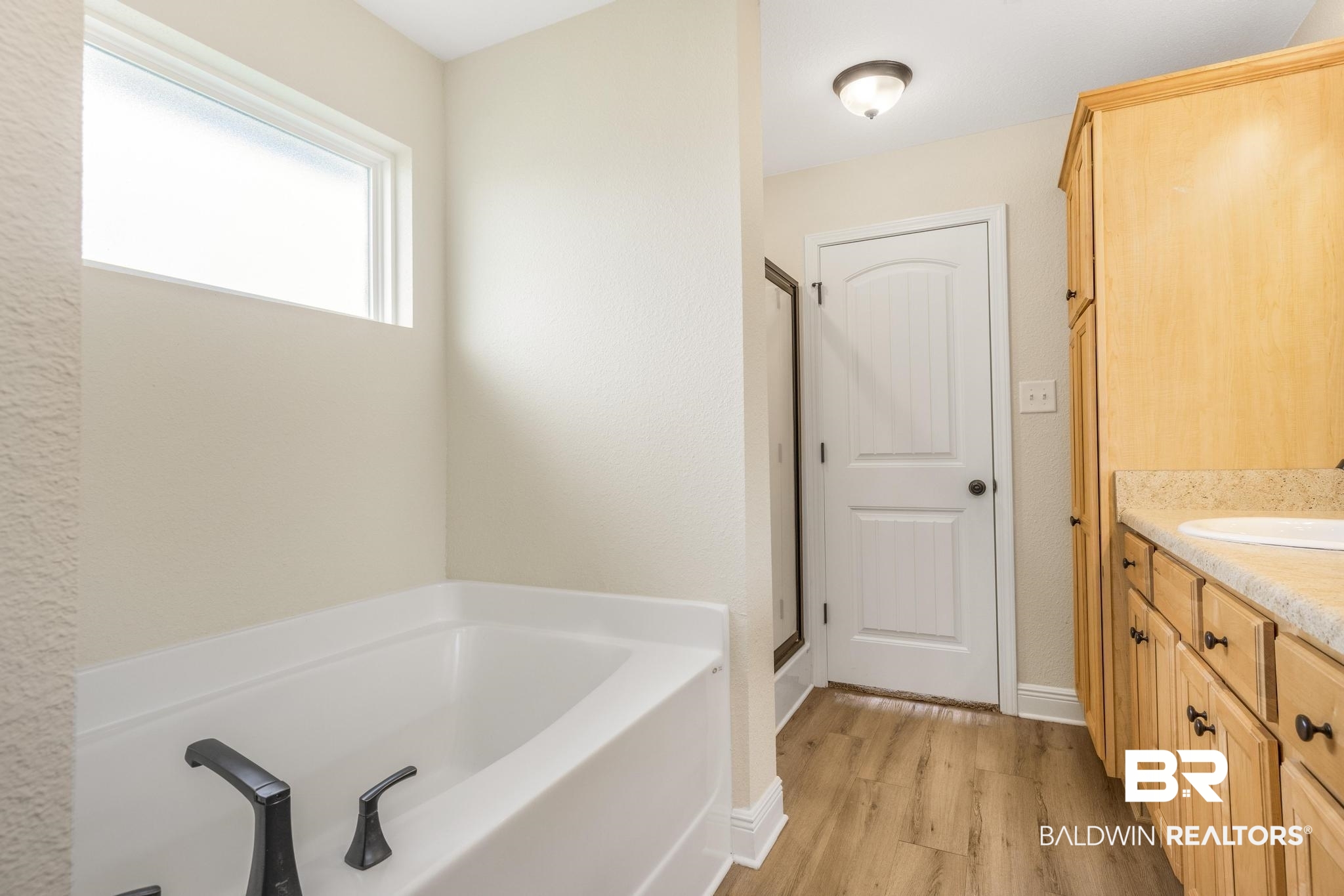 21580 Talbot Lane Robertsdale, AL 36567 - Photo 21 of 25 Full bath featuring a garden tub, vanity, light wood-style flooring, and a stall shower