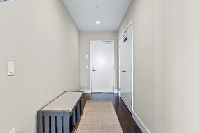 a kitchen with stainless steel appliances granite countertop a refrigerator a sink dishwasher a stove and white cabinets with wooden floor