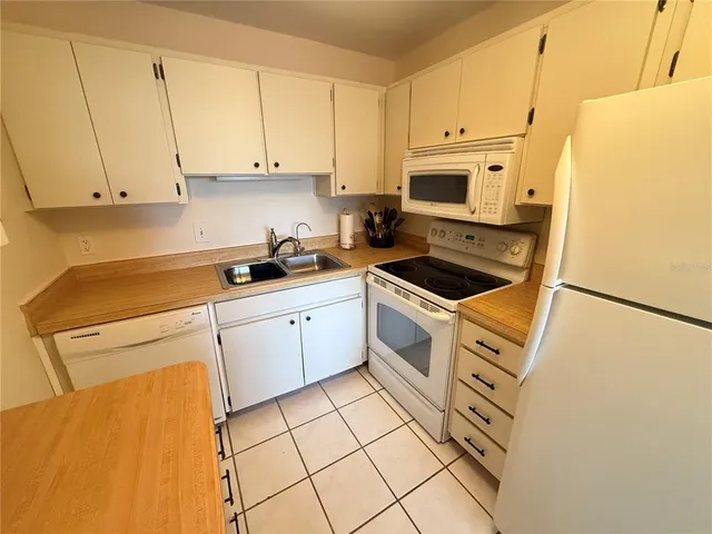 a kitchen with a sink a refrigerator and cabinets