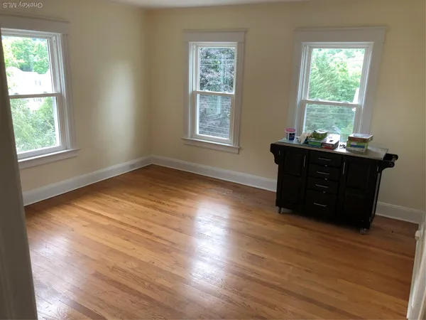 a room with wooden floor and windows
