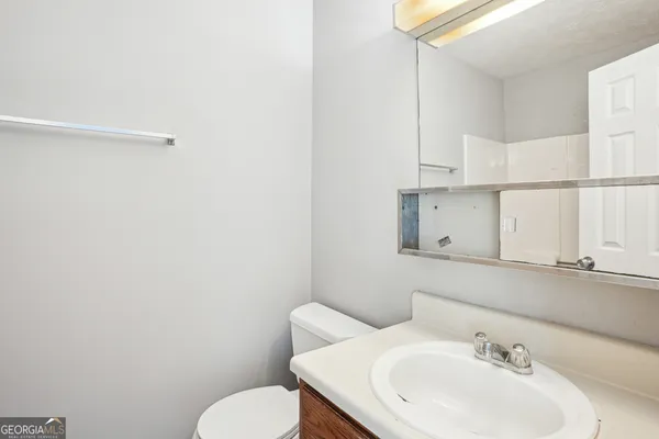 a bathroom with a sink mirror and toilet