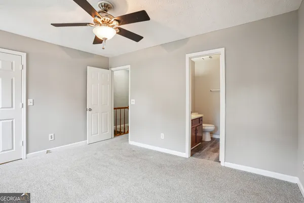 a view of a room with a ceiling fan and a bathroom