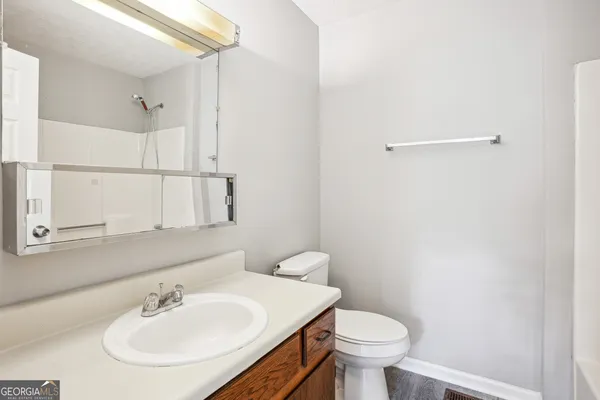 a bathroom with a sink toilet and a mirror