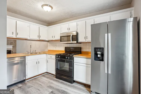 a kitchen with cabinets stainless steel appliances and a counter space
