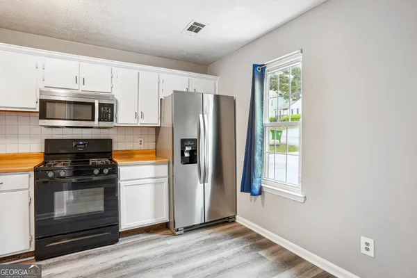 a kitchen with stainless steel appliances a stove a refrigerator and a microwave