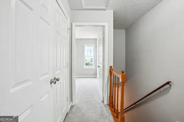 a view of a hallway with wooden floor and a livingroom