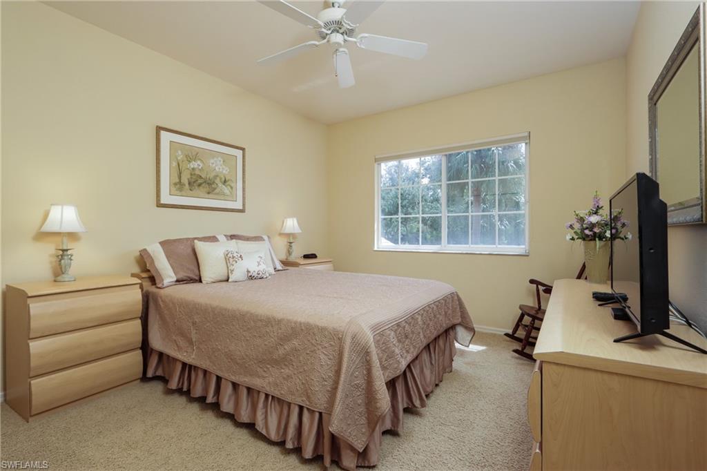 5815 Persimmon Way Naples, FL 34110 - Photo 12 of 24 a bedroom with a bed a couch and a flat tv screen on the dresser