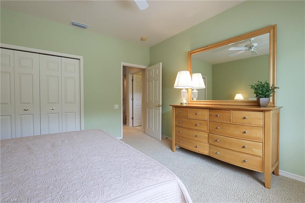 5815 Persimmon Way Naples, FL 34110 - Photo 15 of 24 a bedroom with a bed and a mirror on dresser
