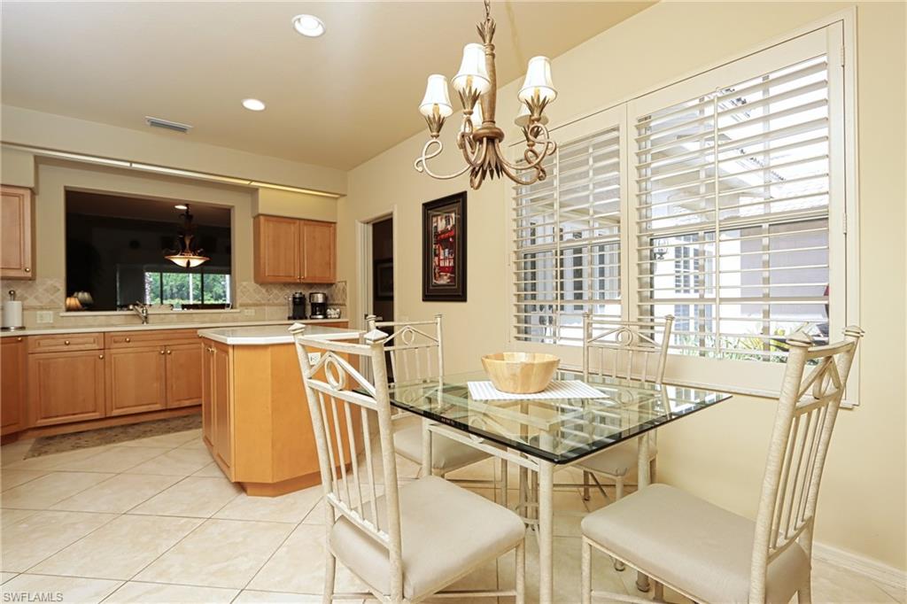 5815 Persimmon Way Naples, FL 34110 - Photo 7 of 24 a kitchen with a table chairs and microwave