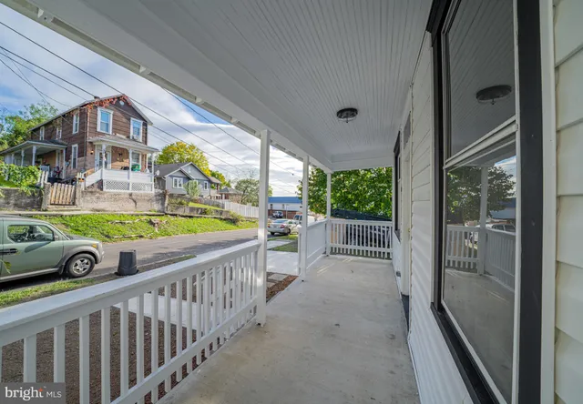 an empty room with windows and fireplace