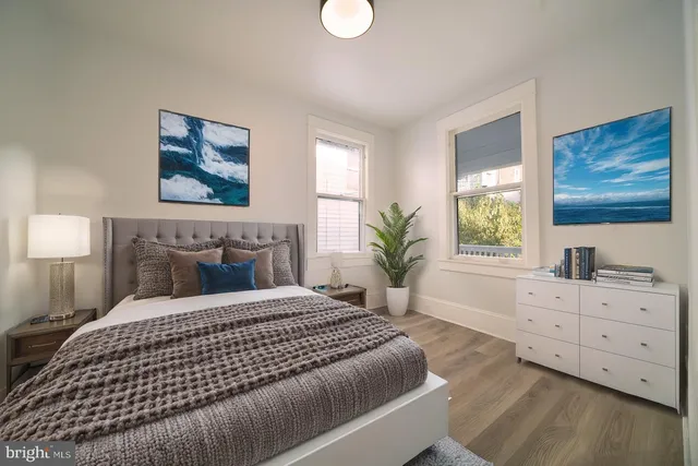a bedroom with a bed and a painting on the wall