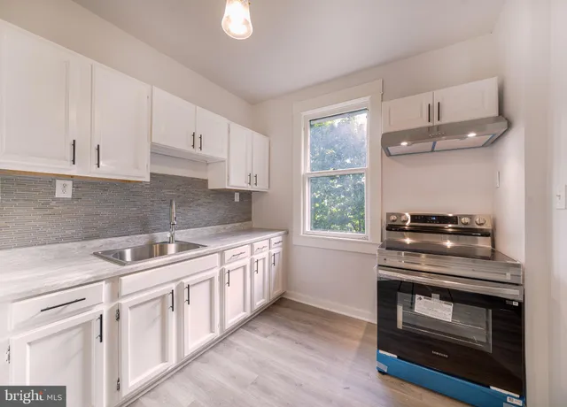 a view of a small space with wooden floor and a window