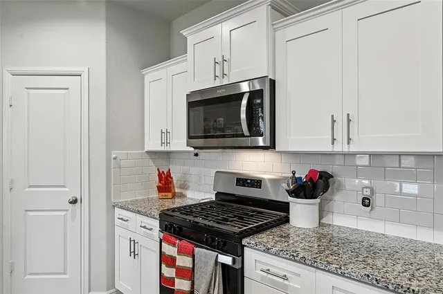 a kitchen with granite countertop lots of counter top space and stainless steel appliances