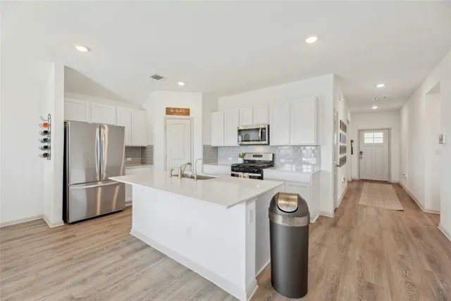 a kitchen with refrigerator a microwave and cabinets