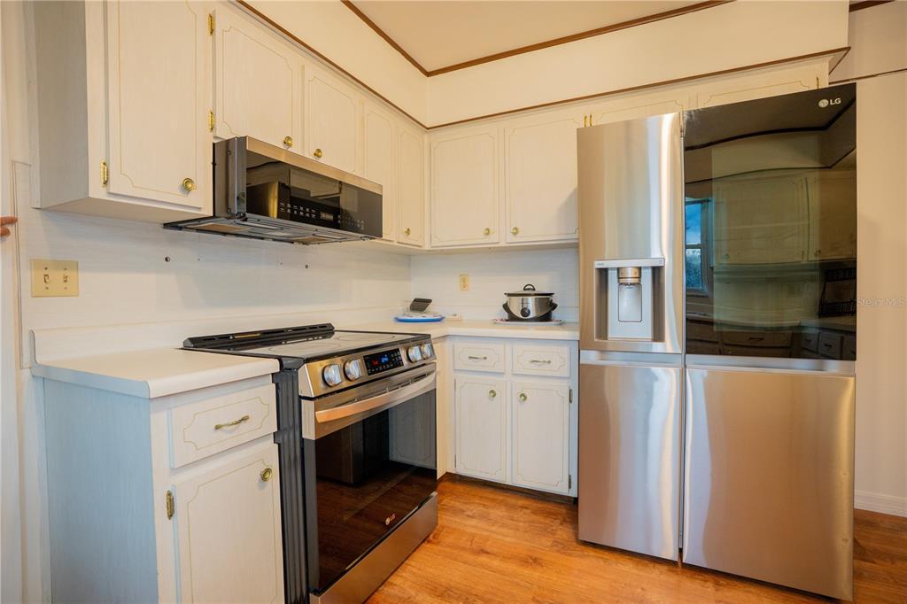 417 L Lanier Road Fort Meade, FL 33841 - Photo 21 of 36 a kitchen with stainless steel appliances white cabinets and a stove top oven