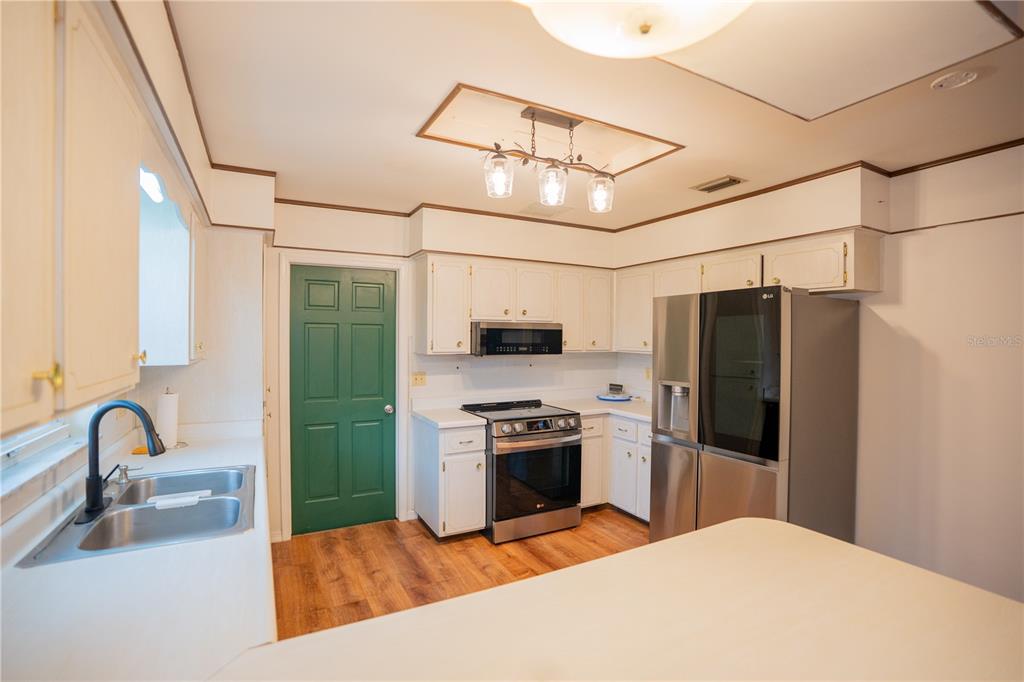 417 L Lanier Road Fort Meade, FL 33841 - Photo 24 of 36 a kitchen with stainless steel appliances granite countertop a refrigerator a stove and a sink with wooden floor