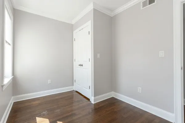a view of an empty room with wooden floor
