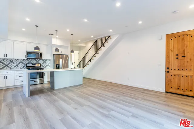 a view of kitchen with microwave and refrigerator