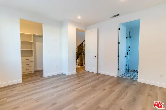 an empty room with closet and wooden floor