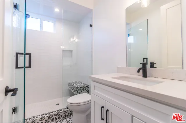 a bathroom with a sink toilet vanity and shower