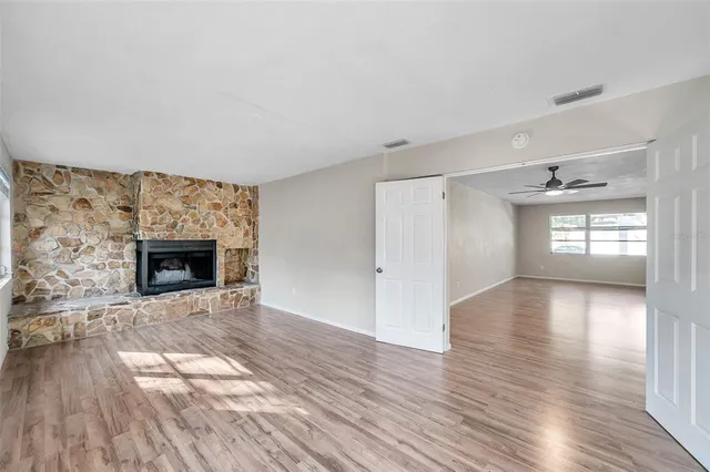 wooden floor fireplace and windows in an empty room