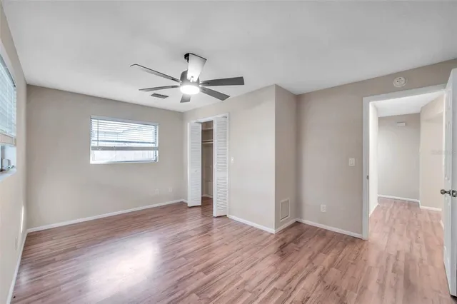 a view of a big room with wooden floor and a ceiling fan