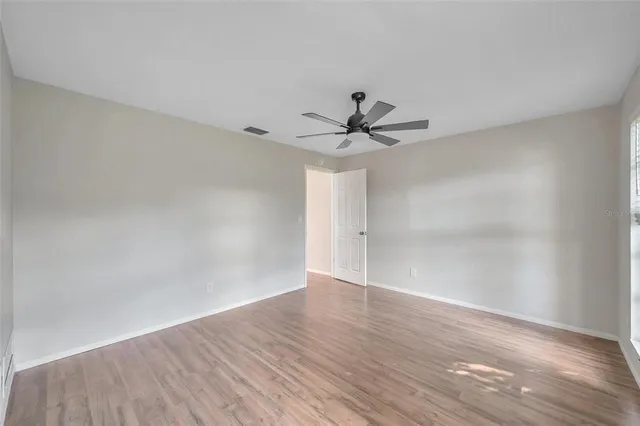 a view of a big room with wooden floor closet and windows