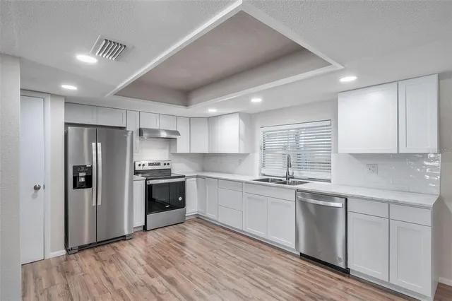 a kitchen with stainless steel appliances a refrigerator sink and cabinets