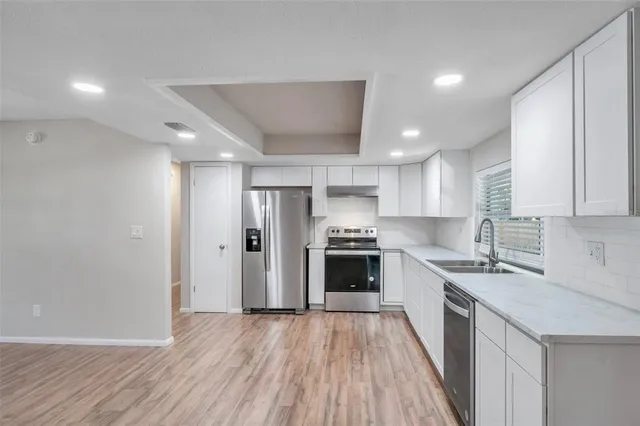 a kitchen with stainless steel appliances a stove a sink a refrigerator and cabinets