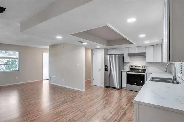 a kitchen with stainless steel appliances kitchen island granite countertop a refrigerator and a stove top oven