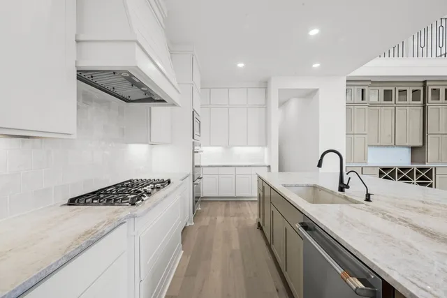 a kitchen with stainless steel appliances granite countertop a sink stove and cabinets