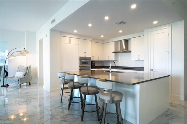 a kitchen with a dining table chairs and a refrigerator
