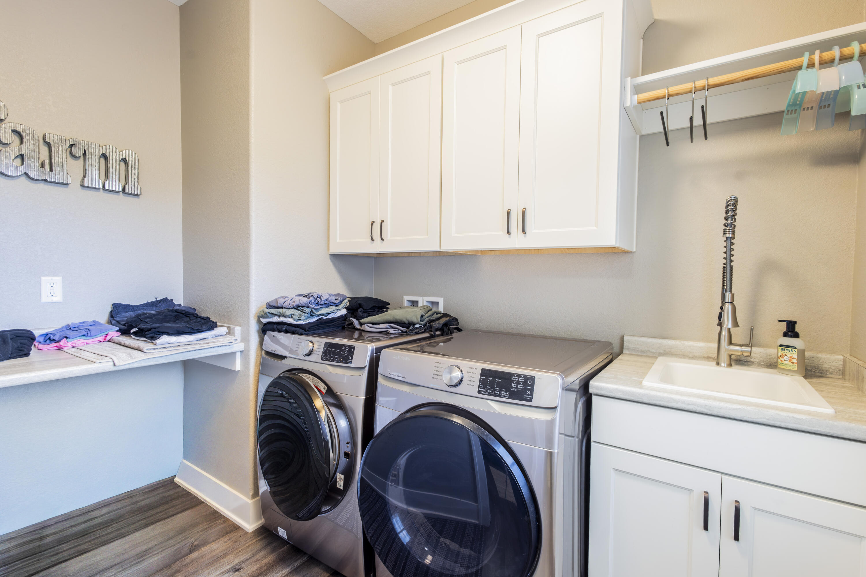 S75W35724 Wilton Road Eagle, WI 53119 - Photo 22 of 42 First floor laundry room, with sink, folding space, cabinets and space to hang dry.