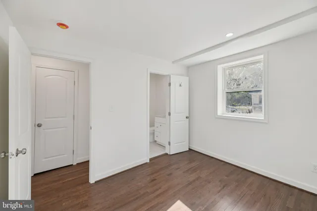 a view of an empty room with wooden floor and closet