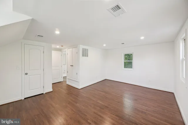 a view of an empty room with wooden floor
