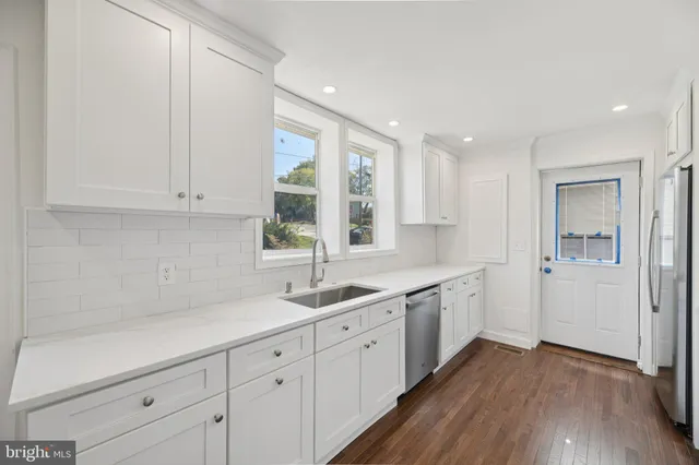 a kitchen with sink cabinets and wooden floor