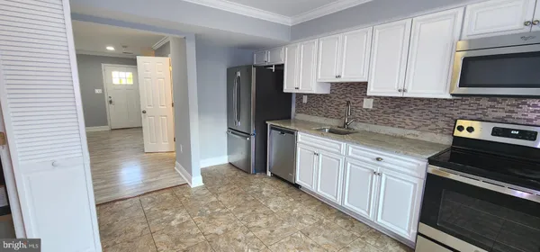 a kitchen with stainless steel appliances granite countertop a refrigerator stove and sink