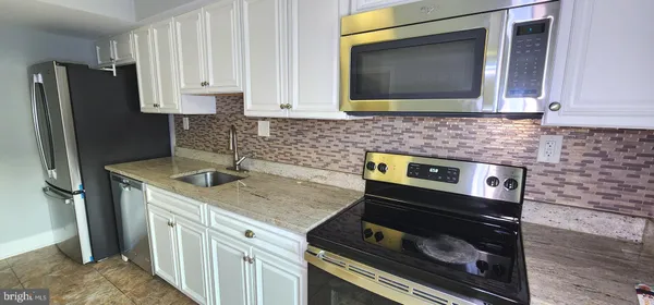 a kitchen with stainless steel appliances granite countertop a stove and a microwave
