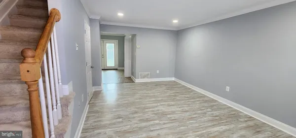 en empty room with wooden floor and a bathroom