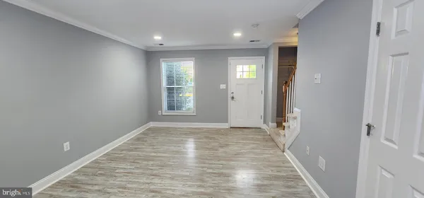 a view of hallway with window and wooden floor