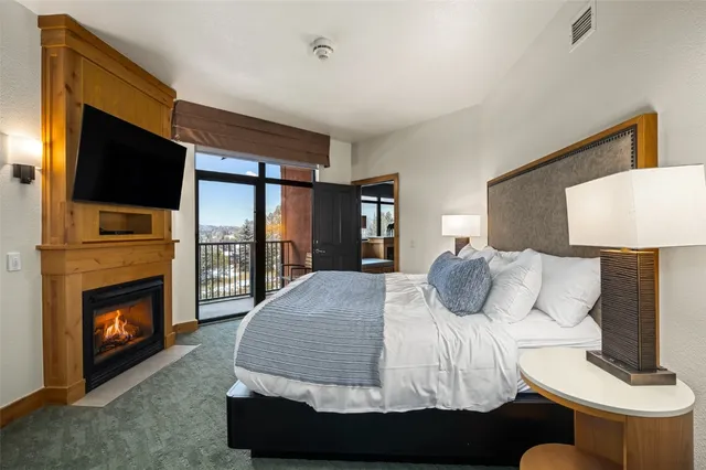 a bedroom with a large bed and a fireplace